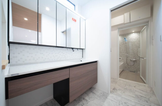 白基調の爽やかな空間に明るい木目の質感が溶け込む効率的な水回り動線の住まい - 感動 - 洗面スペース