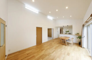 白と木目がやさしく調和する勾配天井の開放感と家事ラク動線を両立した平屋 - センチュリーハウス - LDK