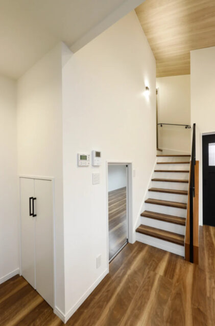 木目の勾配天井が広がる中二階と大型収納を備えた機能的な家 - センチュリーハウス - 階段