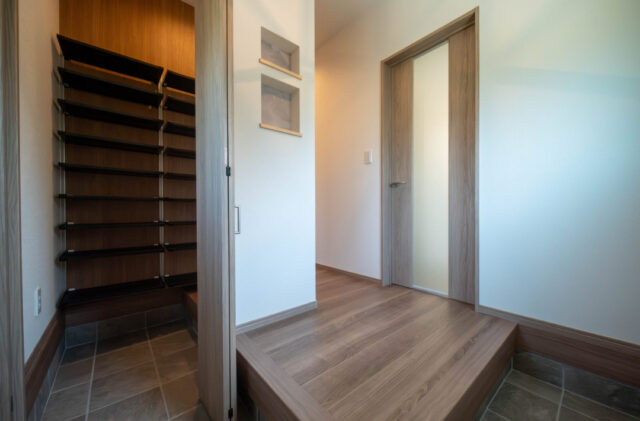 三層の外観と吹き抜けで魅せる木の質感に包まれた機能美あふれる住まい - カマダの家 - 玄関