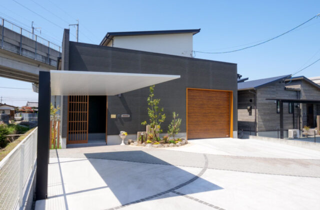 アメリカンガレージと大人モダンな室内が鮮やかな対比を描く段差リビングのある家 - 外観正面
