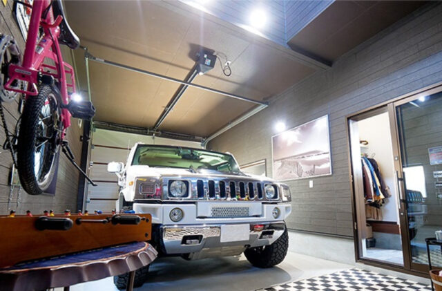 アメリカンガレージと大人モダンな室内が鮮やかな対比を描く段差リビングのある家 - ガレージ