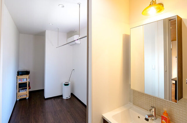 アメリカンガレージと大人モダンな室内が鮮やかな対比を描く段差リビングのある家 - リブワーク - 洗面・ドライルーム