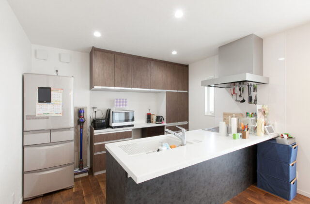 室内干しを叶える効率的な家事動線とダークウッドが映えるシンプルな2階建て - リブワーク - キッチン