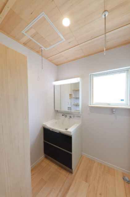 木のぬくもりの中にピンクのキッチンが映えるソリッドな外観の平屋 - もみの木ハウス・かごしま - 洗面スペース