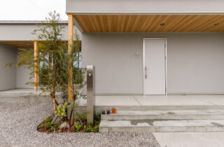 グレーの塗り壁と木の温かみが調和する家事ラク設計の平屋 - 中池組 - 玄関・外観