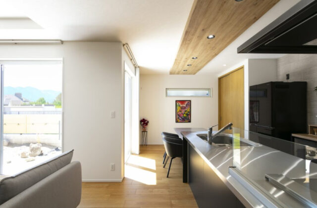 丸窓がアクセントの白壁と木が調和する上質モダン平屋 - ネオデザインホーム - キッチン・ダイニング