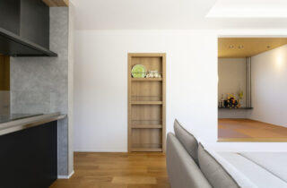 丸窓がアクセントの白壁と木が調和する上質モダン平屋 - ネオデザインホーム - 本棚扉