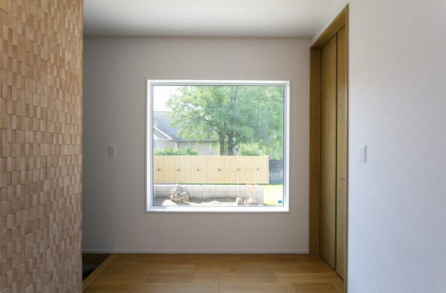 丸窓がアクセントの白壁と木が調和する上質モダン平屋 - ネオデザインホーム - 玄関ホール