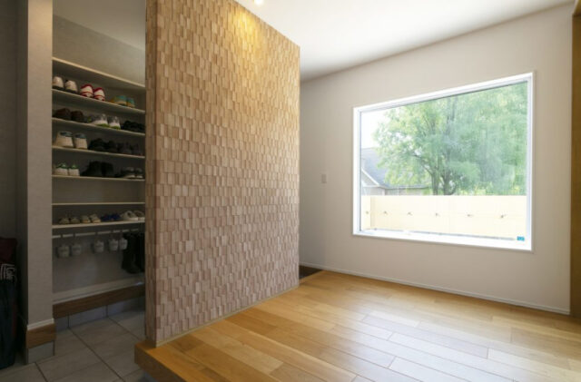 丸窓がアクセントの白壁と木が調和する上質モダン平屋 - ネオデザインホーム - 玄関・収納