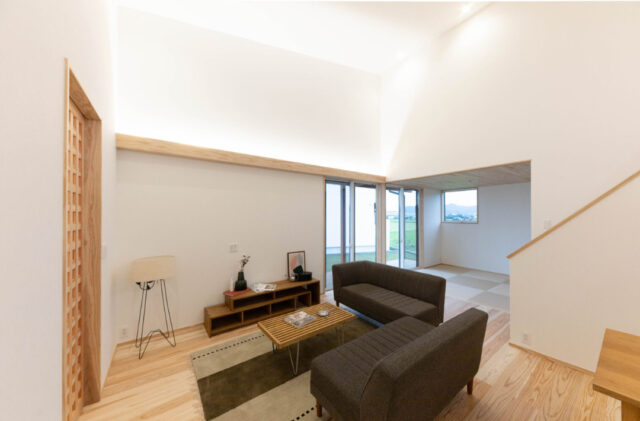 スタイリッシュな片流れ屋根と重厚感ある外観が映えるロフトと和室を備えた平屋 - おばま工務店 - リビング・和室