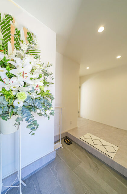 ブルーのガルバリウムと大屋根が映えるホテルライクなサロン付き平屋 - トータルハウジング - 玄関