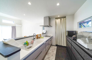 ブルーのガルバリウムと大屋根が映えるホテルライクなサロン付き平屋 - トータルハウジング - キッチン