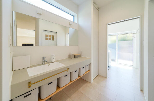 シックなダークの外装に光溢れるホワイトの空間が映える開放的な平屋 - トータルハウジング - 洗面スペース