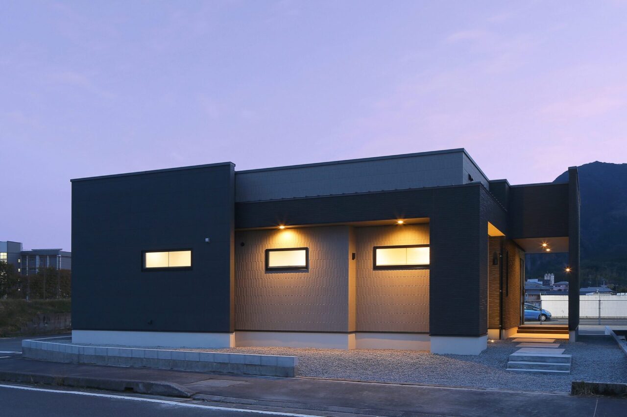 穏やかなダークトーンに立体感が映える約24帖LDKの大空間モダン平屋 - カマダの家 - 夜外観