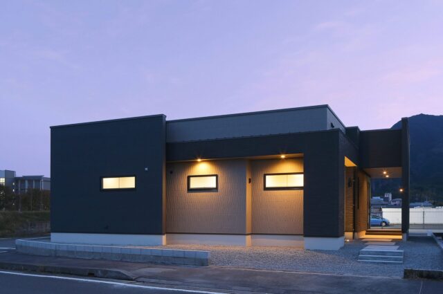 穏やかなダークトーンに立体感が映える約24帖LDKの大空間モダン平屋 - カマダの家 - 夜外観